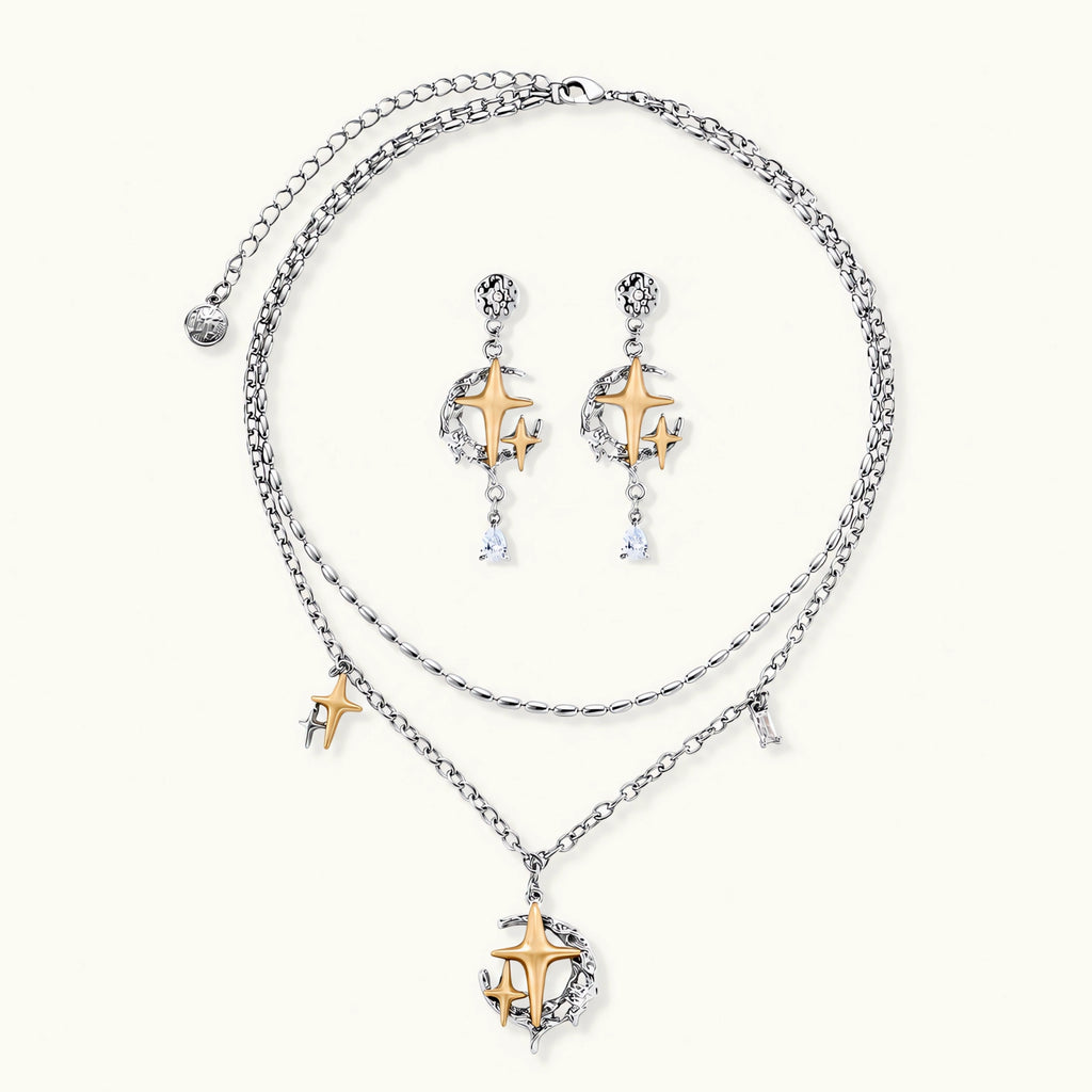 Delicate eco-brass jewelry set featuring gold star and silver moon crescents with clear zirconia crystal drops on cream background