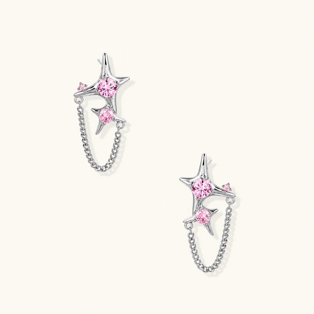 Pair of silver star-shaped ear climbers with pink zirconia stones connected by delicate chains