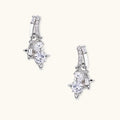 White gold-plated huggie earrings with geometric emerald-cut zirconia clusters in starburst formation on beige background